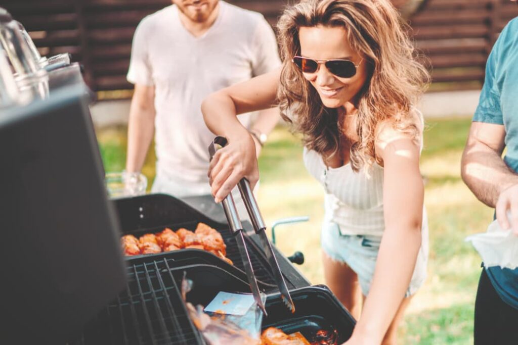 Menschen am Griller - Outdoor Küche aus Edelstahl mit integriertem Elektro Einbaugril